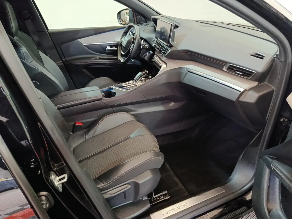 Vue intérieure côté passager du Peugeot 3008 noir 2022, mettant en valeur les sièges en cuir et le tableau de bord moderne.