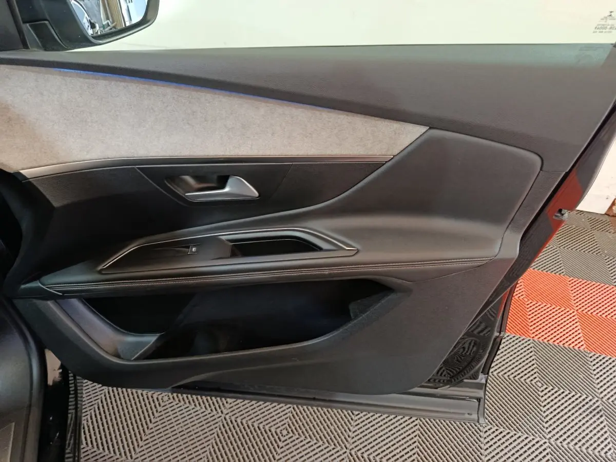 Vue intérieure de la porte côté gauche d’un Peugeot 3008 noir, avec garniture noire et insert beige clair.