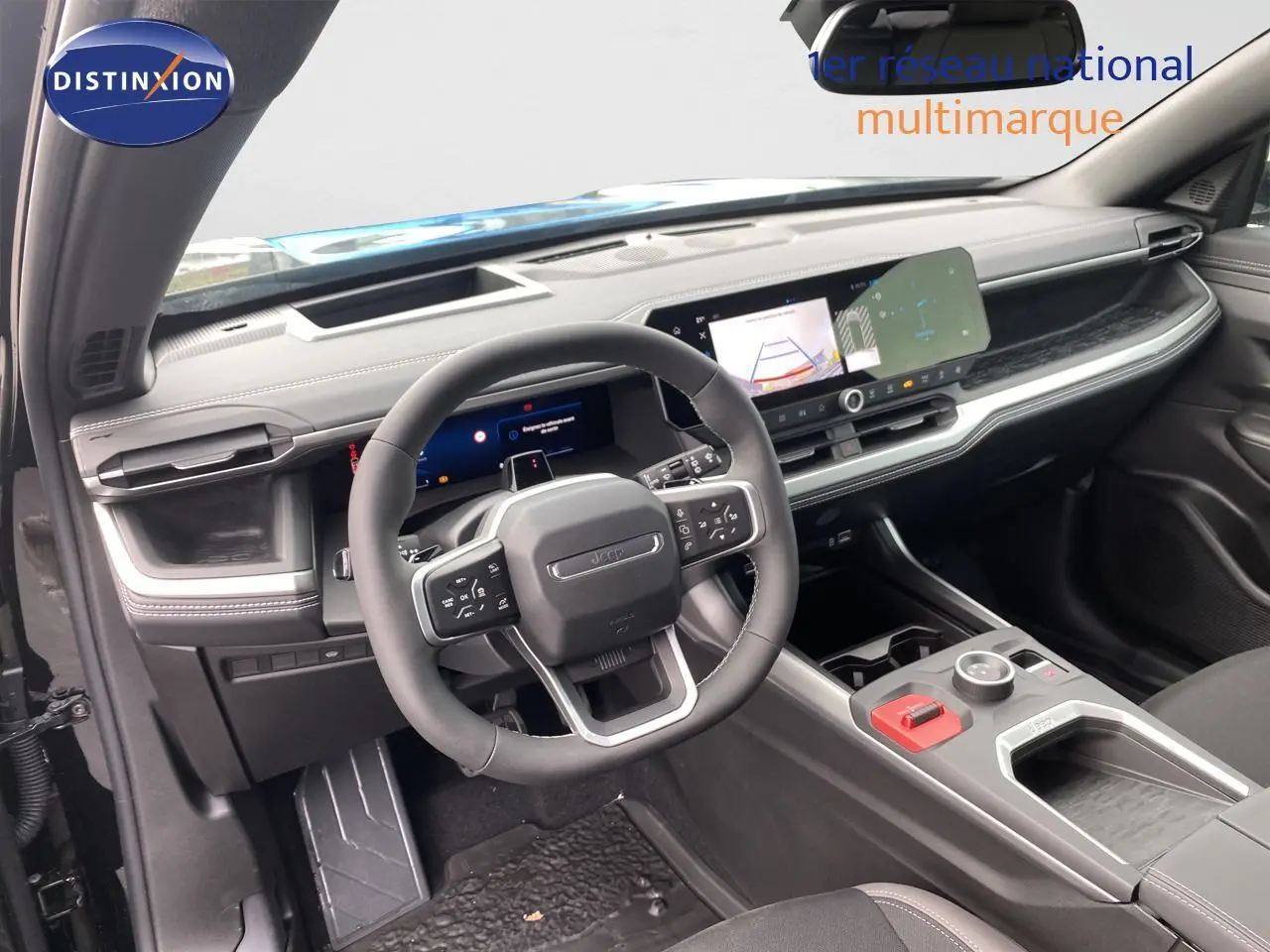 Vue intérieure du tableau de bord et volant du Jeep Compass 2026 noir Vulcano, avec écran tactile et commandes au volant.