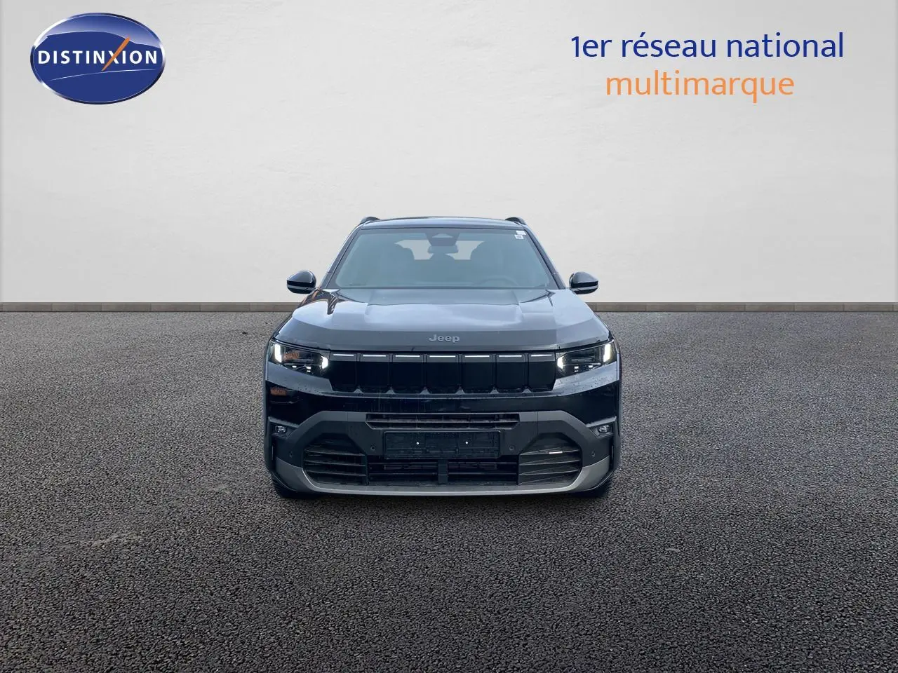 Vue frontale d'un Jeep Compass noir Vulcano métallisé, mettant en valeur sa calandre et ses phares LED allumés.