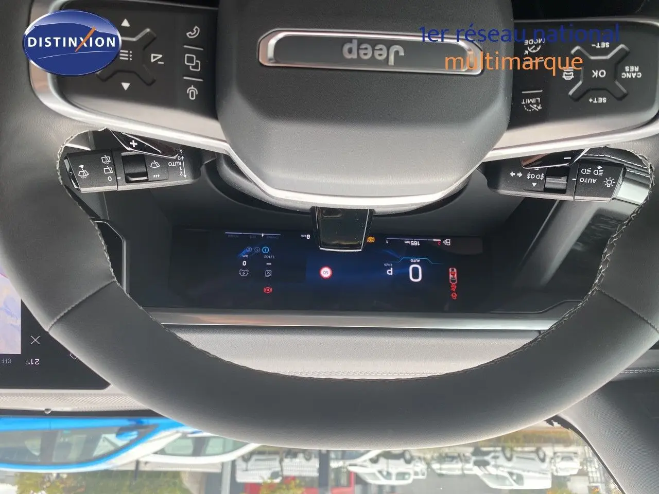 Vue rapprochée du volant noir cuir du Jeep Compass 2026 avec commandes intégrées et tableau de bord numérique visible.