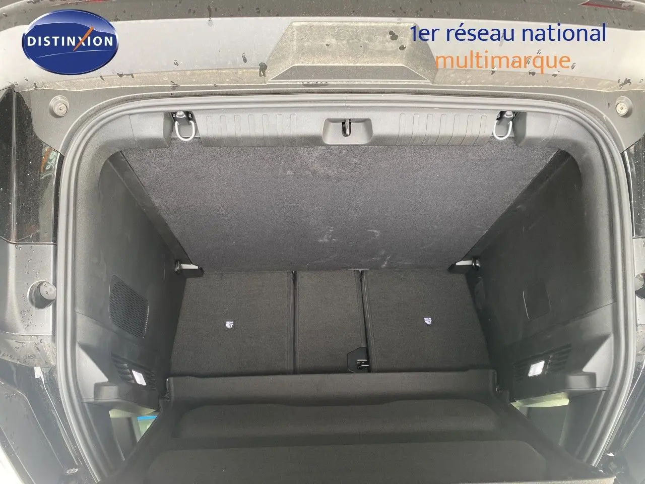 Vue plongeante sur le coffre ouvert du Jeep Compass noir Vulcano, montrant un espace de rangement propre et spacieux.