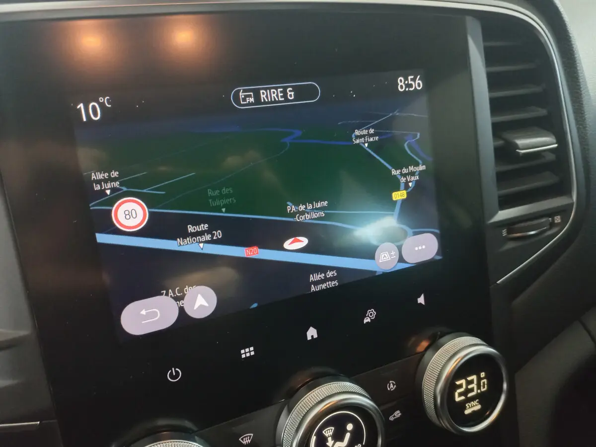 Écran tactile central de navigation et commandes climatisation dans l'habitacle d'une Renault Mégane blanche 2022.