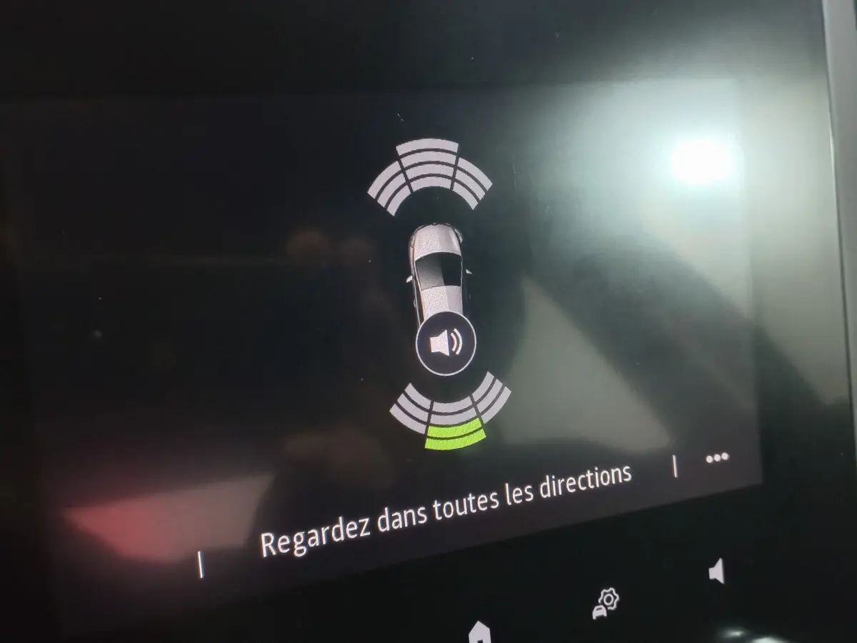Affichage tactile de la Renault Mégane Business blanc, montrant l'alerte de capteurs de proximité arrière.