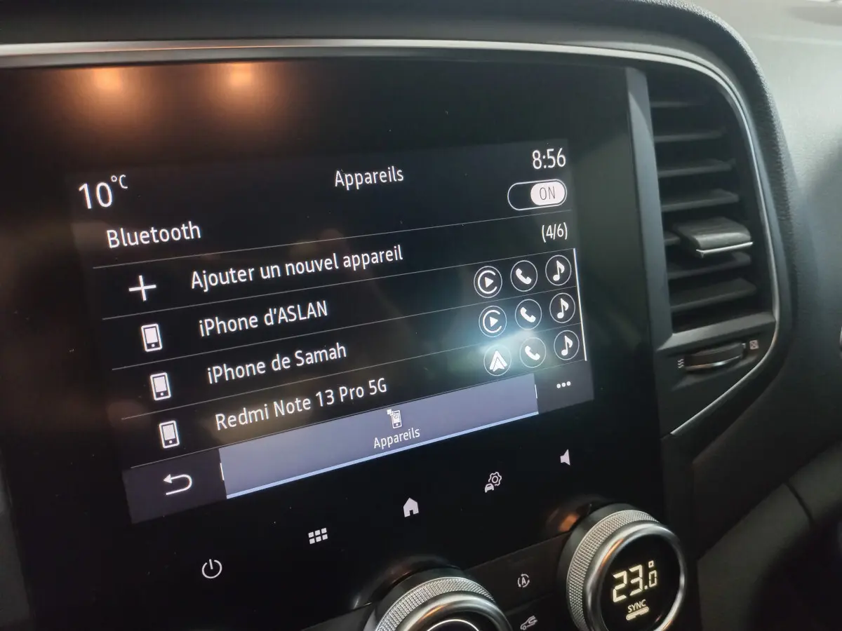 Écran tactile central de la Renault Mégane Business blanc, affichant les connexions Bluetooth et la température intérieure.
