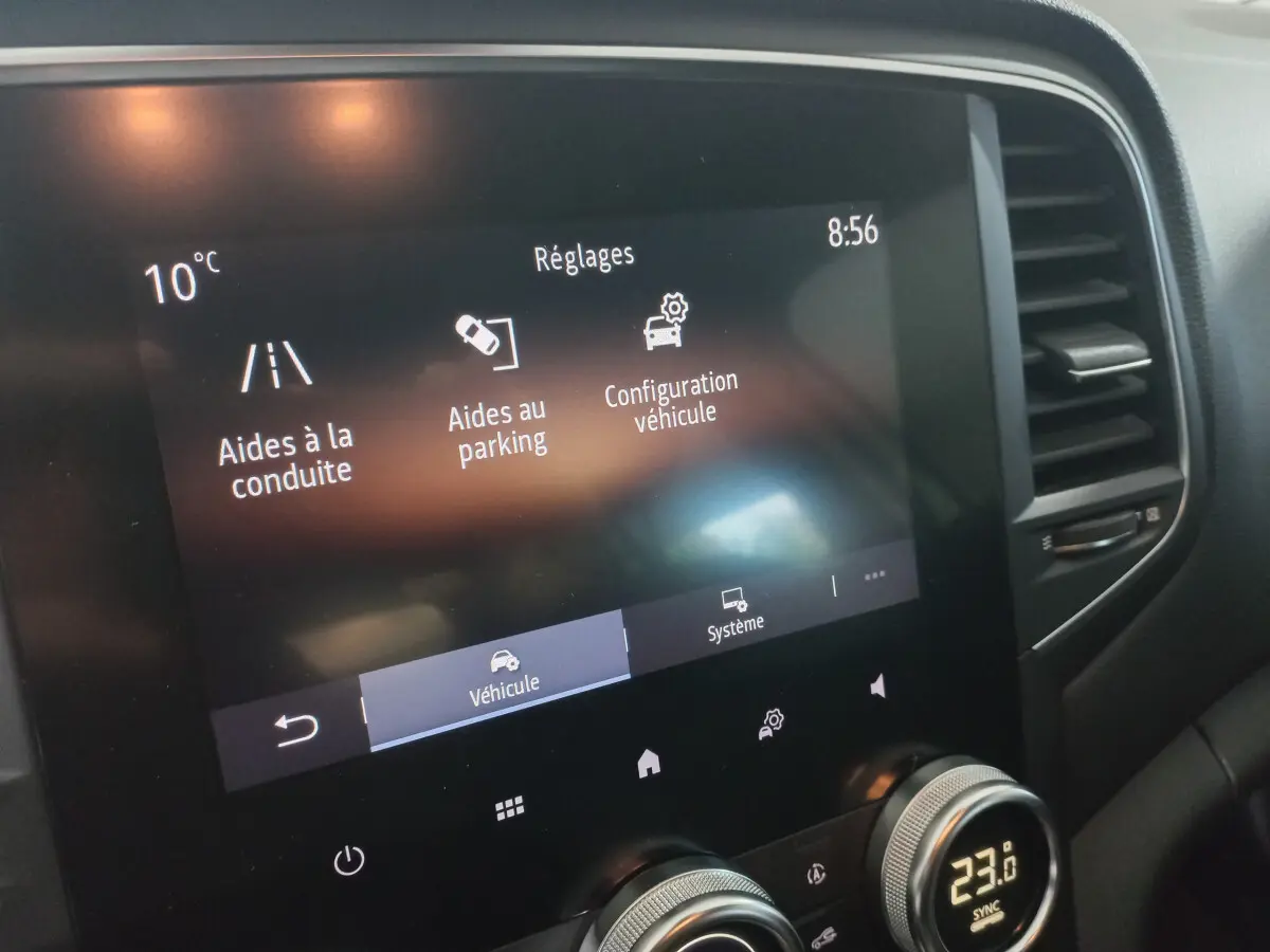 Écran tactile central affichant les réglages d’aide à la conduite et parking dans une Renault Mégane blanche 2022.