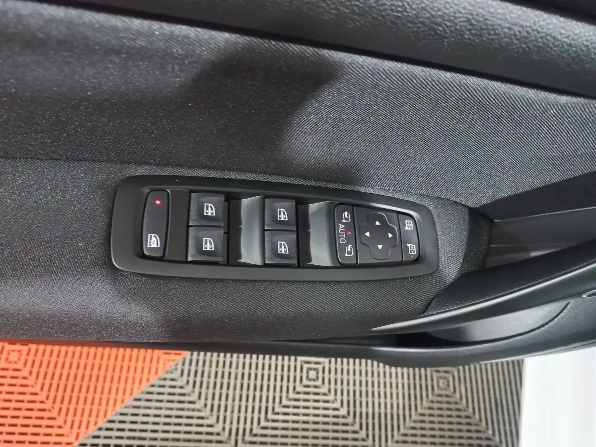 Commande des vitres électriques côté conducteur en gros plan sur porte noire d'une Renault Mégane blanche 2022