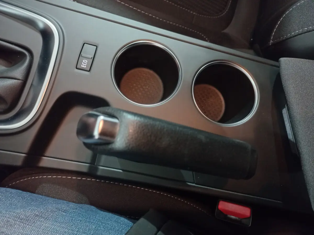 Gros plan sur la console centrale intérieure de la Renault Mégane Business, avec frein à main et bouton Eco visibles.