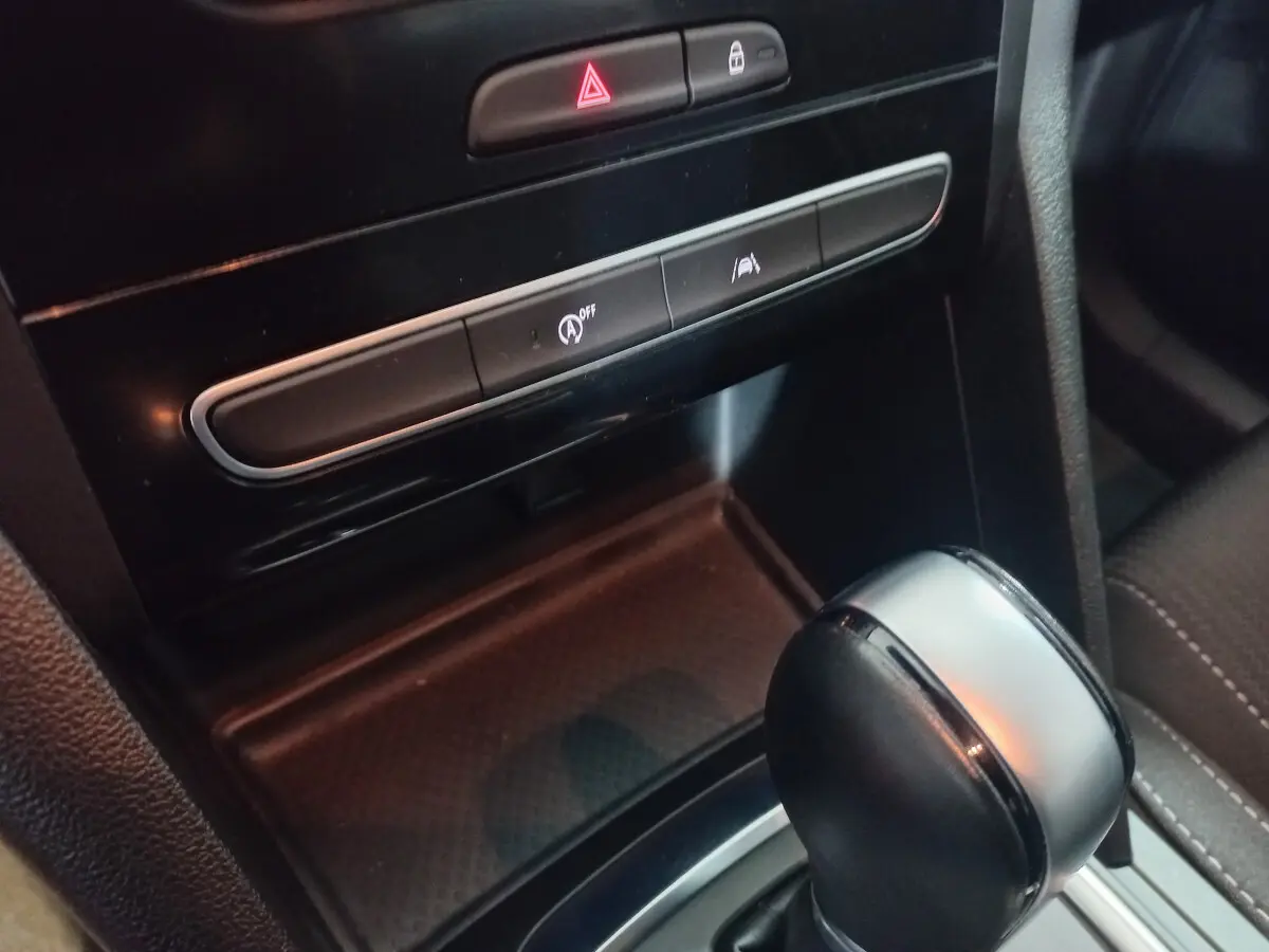 Gros plan sur le levier de vitesse automatique et les commandes centrales noires du tableau de bord de la Renault Mégane Business.