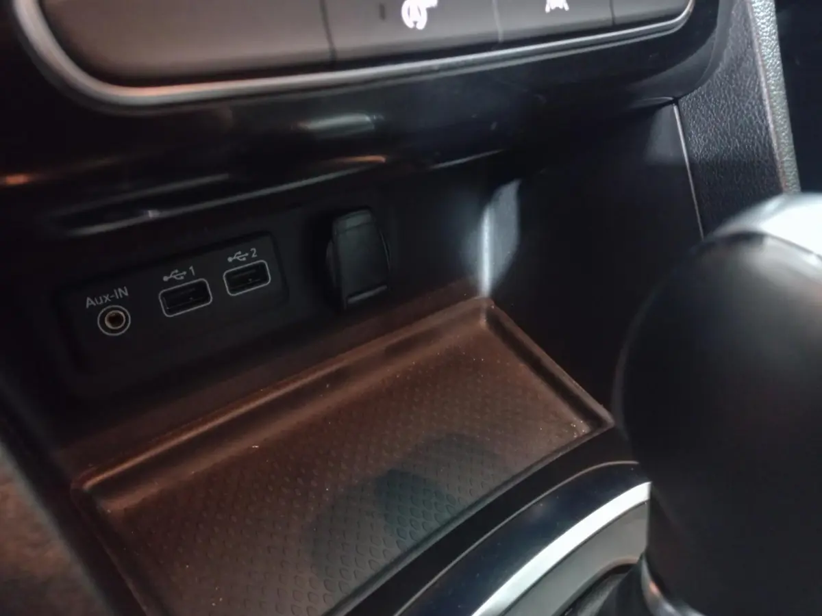 Vue rapprochée de la console centrale noire de la Renault Mégane Business avec ports USB et prise Aux-In visibles