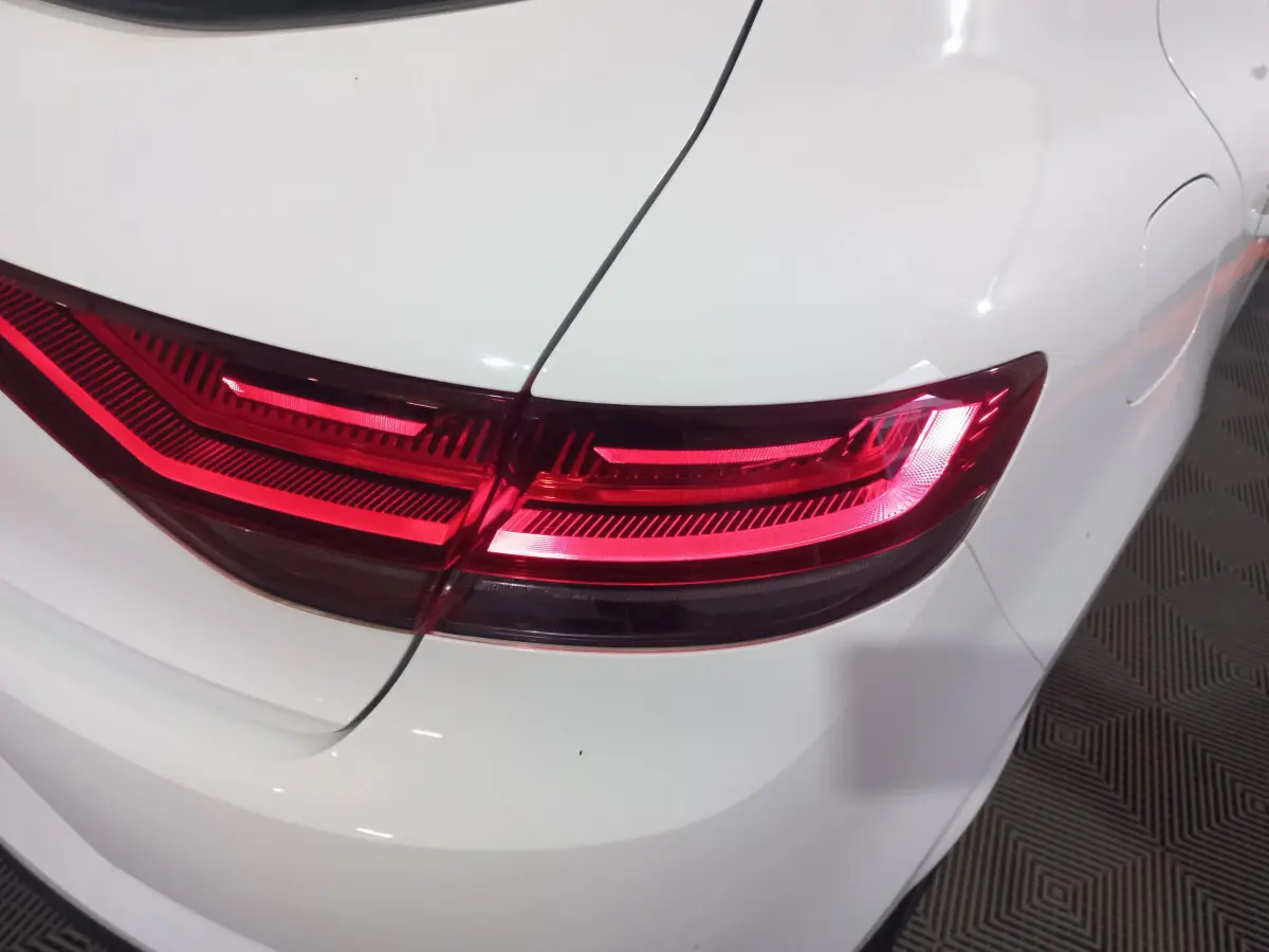 Gros plan sur le feu arrière droit rouge d’une Renault Mégane Business blanche de 2022, vue arrière.