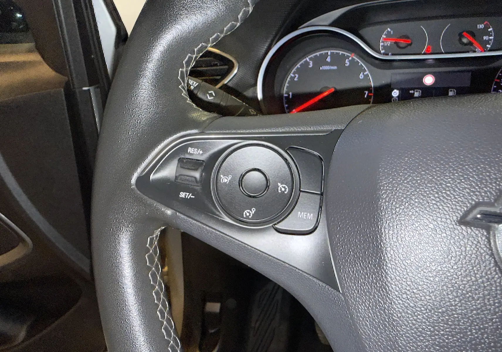 Gros plan sur le volant côté gauche de l’Opel Crossland 2023, montrant les commandes de régulateur de vitesse et le tableau de bord partiel.