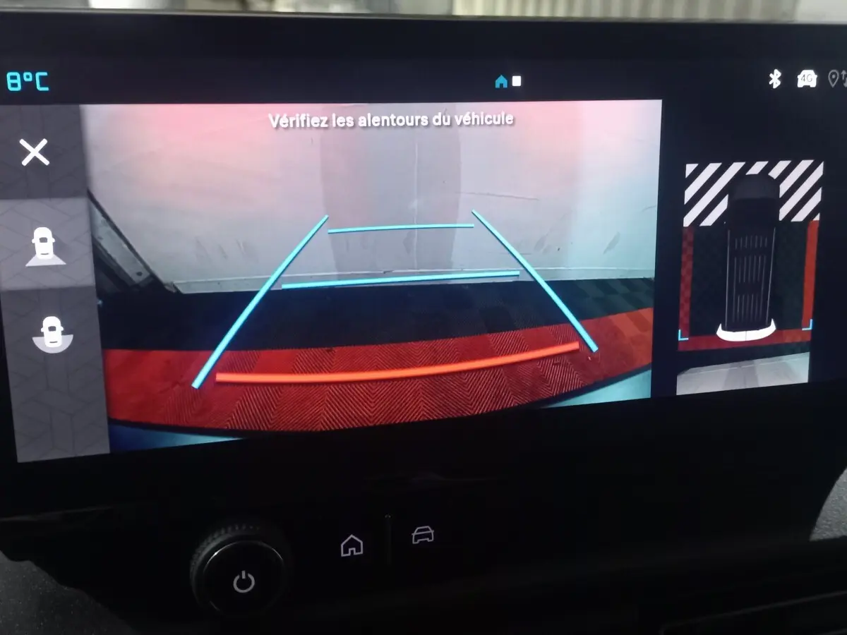 Vue de l'écran de caméra de recul du Citroën Berlingo blanc, avec lignes de guidage et affichage de l'environnement arrière.