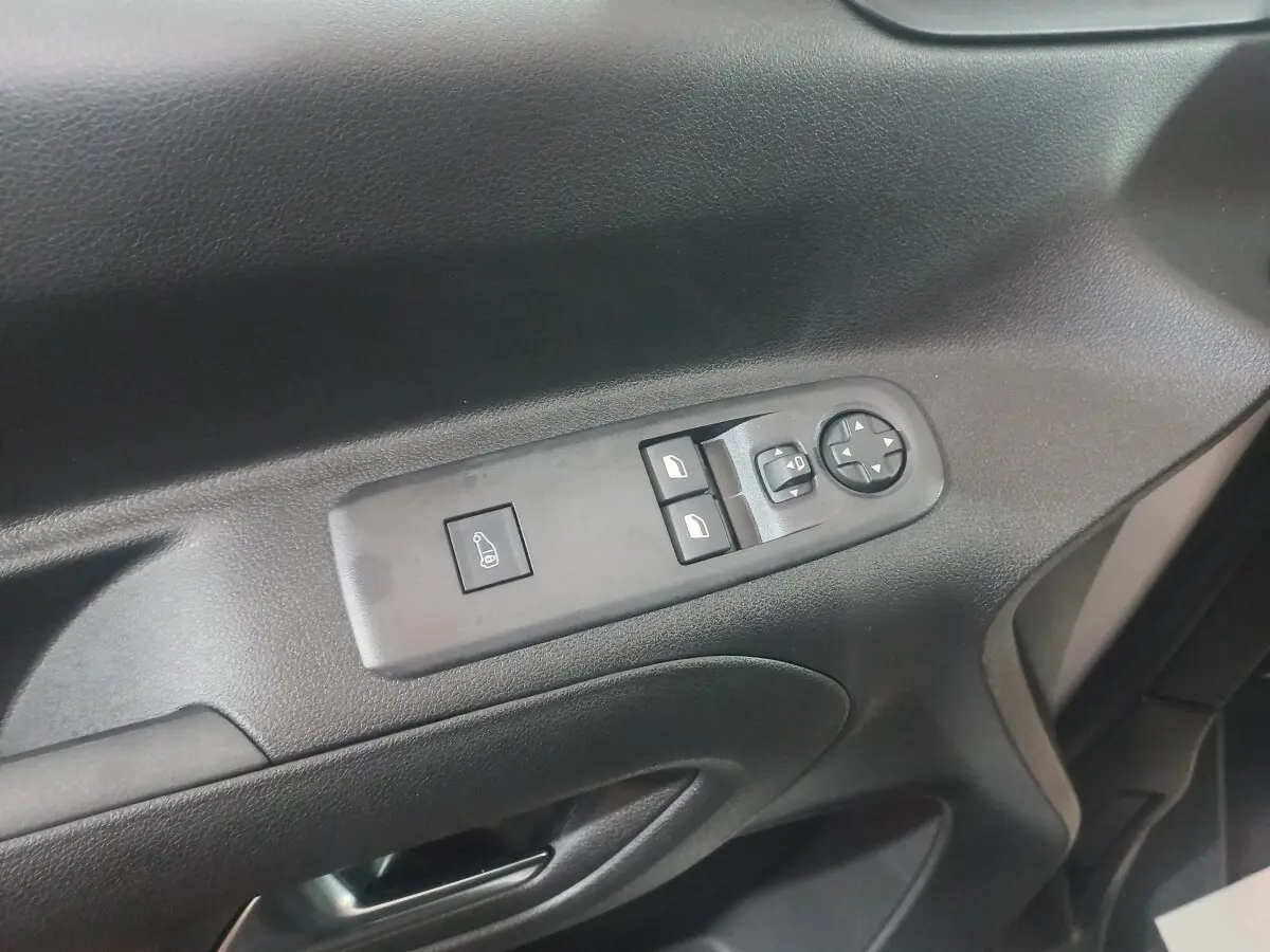 Gros plan sur la commande des vitres et rétroviseurs côté conducteur du Citroën Berlingo XL 2025 en intérieur noir.