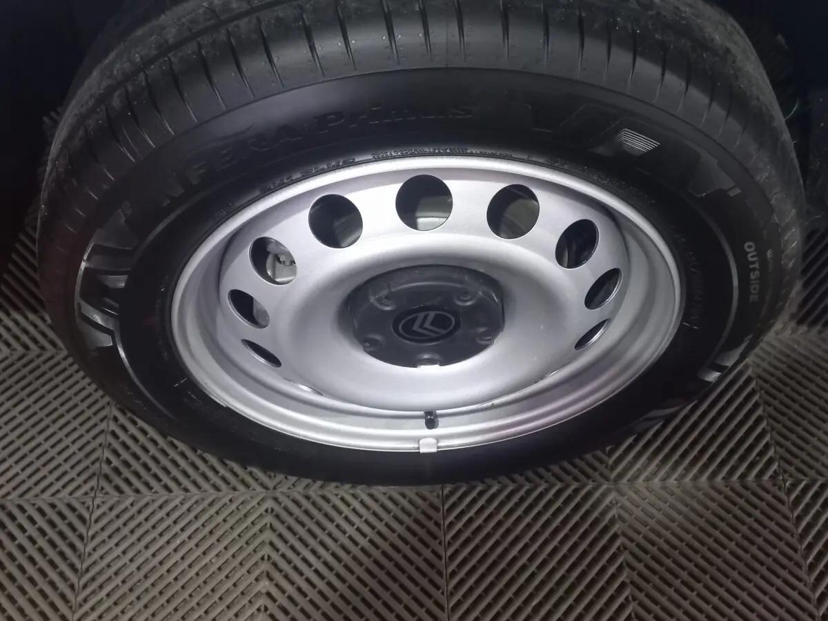 Gros plan sur la roue acier avec jante argentée et logo Citroën au centre du Berlingo blanc 2025.