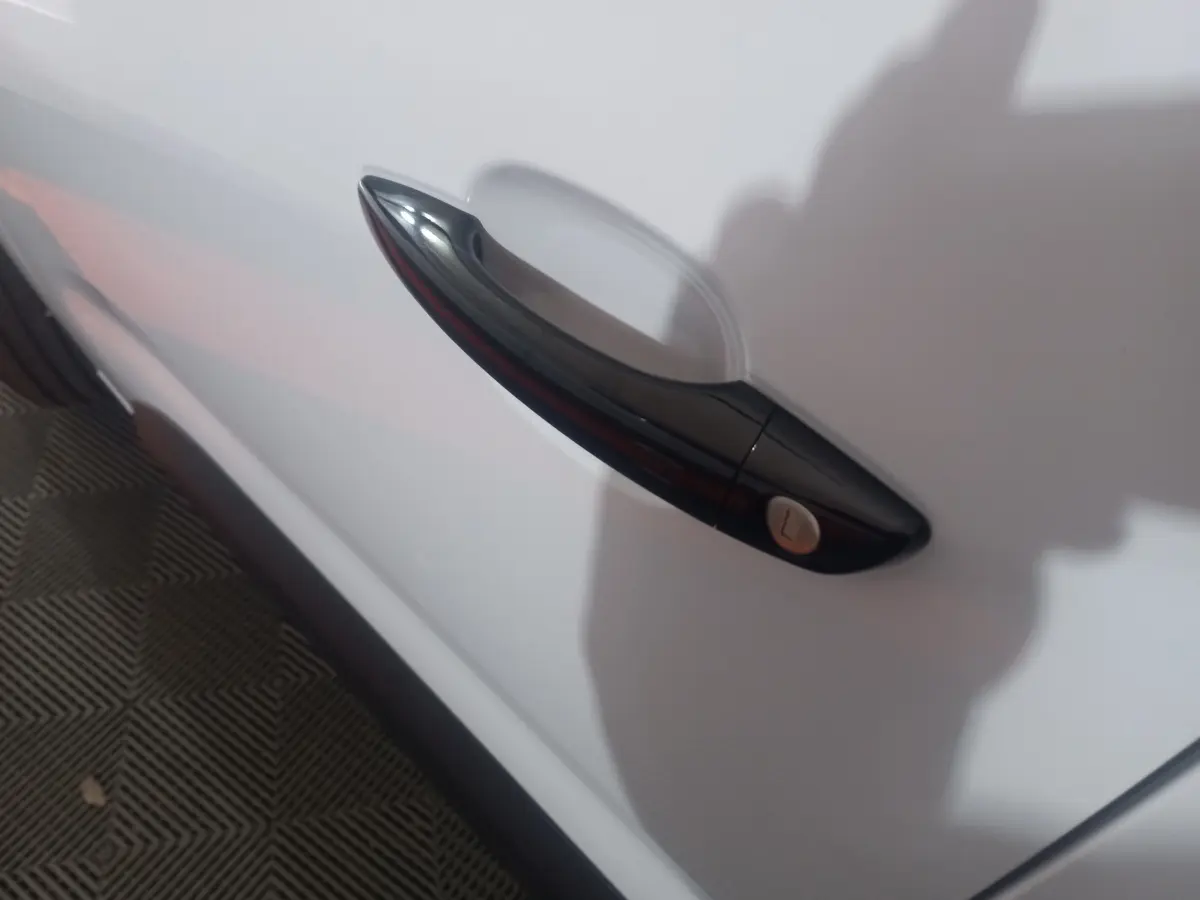 Poignée de porte noire en gros plan sur la porte blanche côté gauche d'un Citroën Berlingo XL 2025.