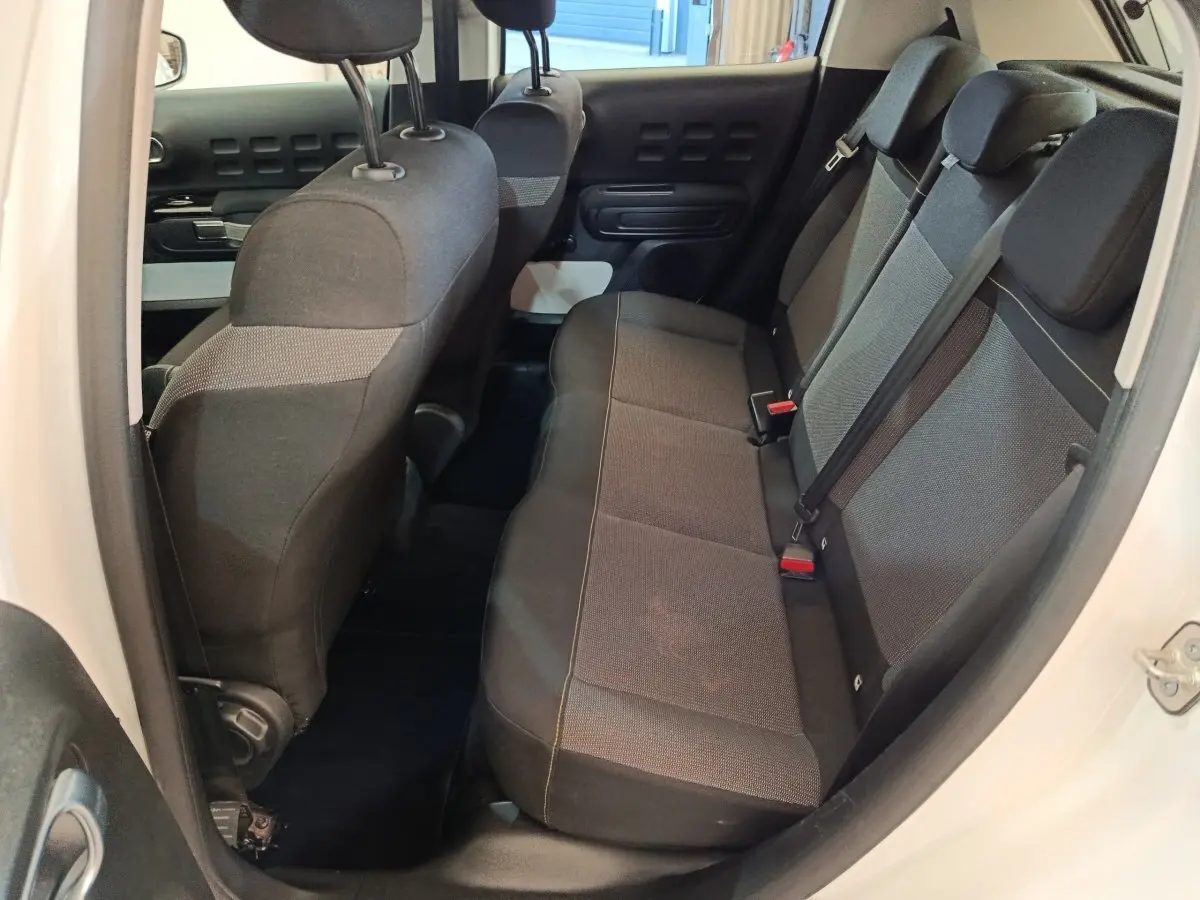 Vue intérieure côté droit montrant la banquette arrière noire et grise du Citroën C3 blanc de 2021.