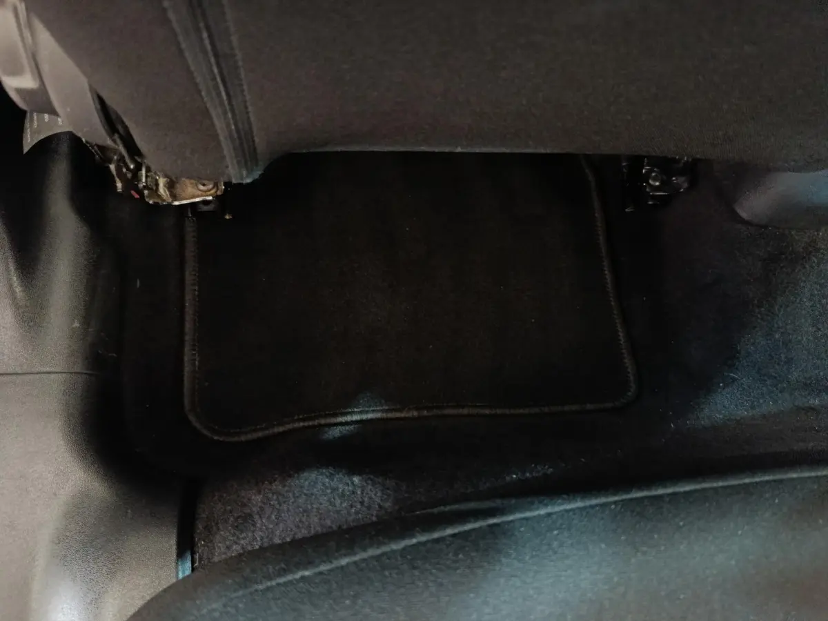 Vue rapprochée du sol et tapis noir sous le siège arrière d'une Citroën C3 blanche 2021.