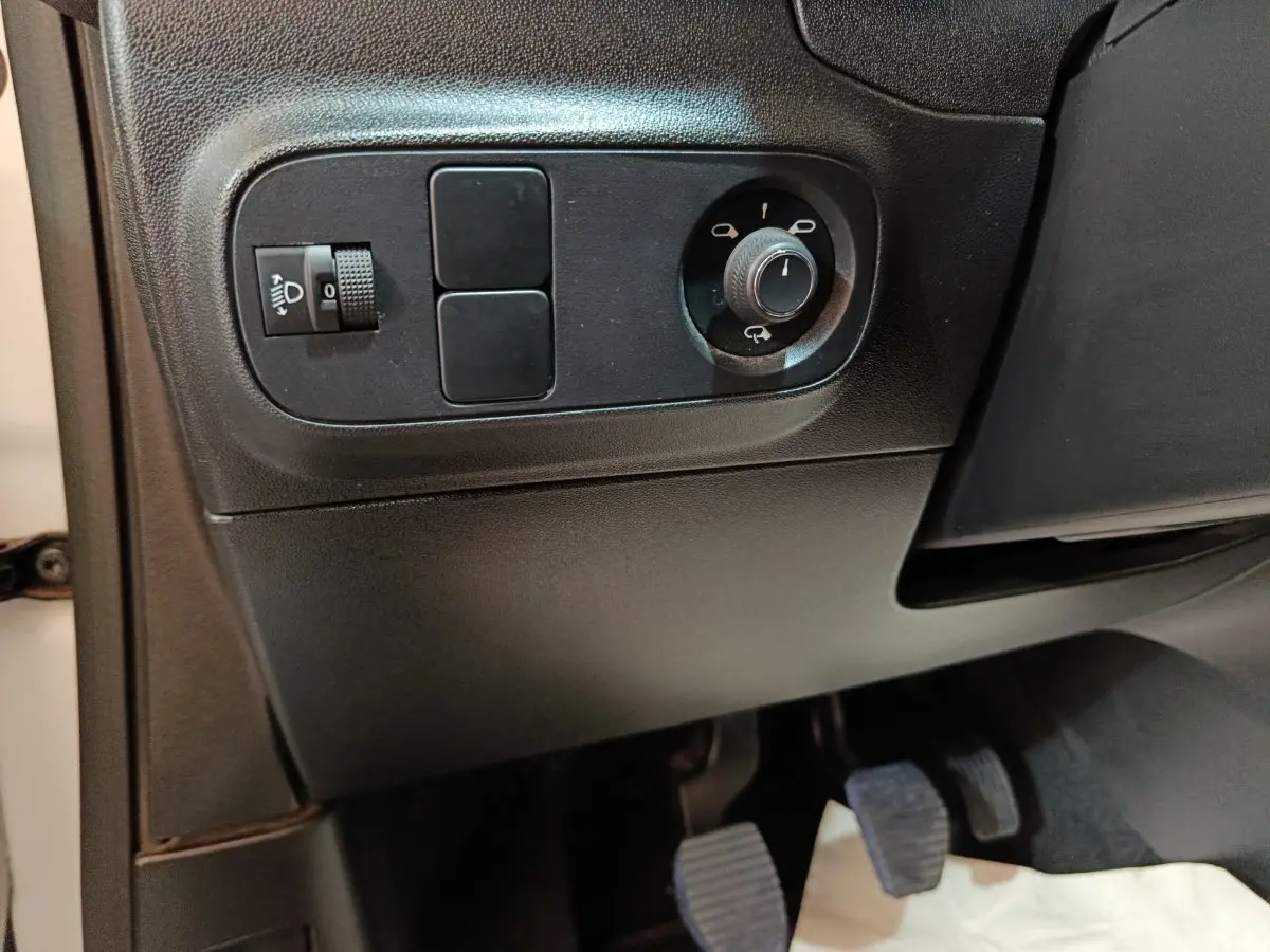 Détail du panneau de réglage des phares et des rétroviseurs côté gauche intérieur d'une Citroën C3 blanche 2021.