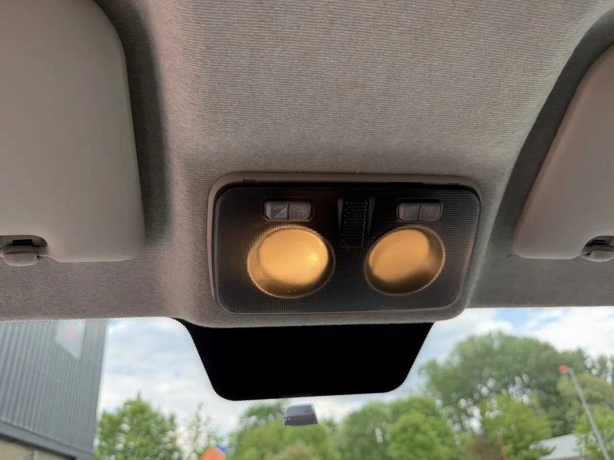 Plafonnier intérieur allumé vu de dessous dans un Peugeot Boxer Fourgon blanc, 3/4 avant, extérieur flou visible.