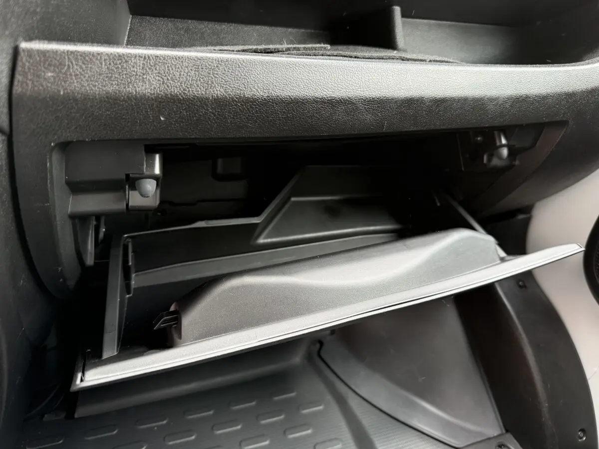 Vue rapprochée de la boîte à gants ouverte côté passager du Peugeot Boxer Fourgon blanc, intérieur noir.