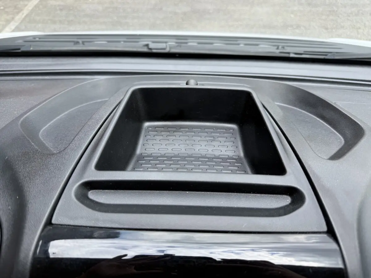 Vue rapprochée du rangement central noir sur le tableau de bord du Peugeot Boxer Fourgon blanc 2023.
