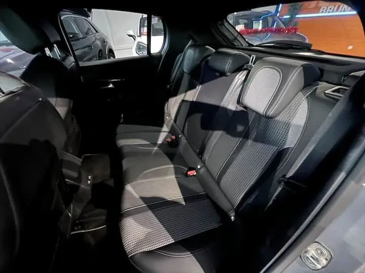 Vue intérieure arrière de la Peugeot 208 E-208 GT 2022, sièges arrière en tissu noir avec surpiqûres grises.