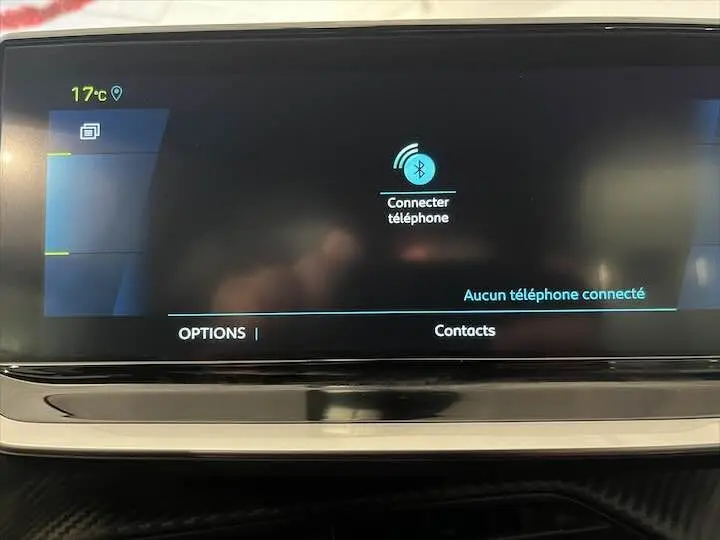 Écran tactile central de la Peugeot e-208 GT 2022 affichant la connexion Bluetooth pour téléphone, intérieur noir.
