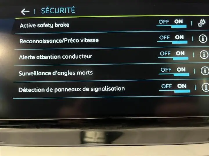 Écran tactile intérieur de la Peugeot e-208 GT 2022 montrant les réglages de sécurité activés.
