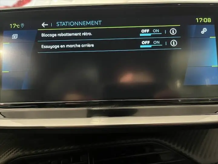 Écran tactile intérieur de la Peugeot e-208 GT 2022 affichant les réglages de stationnement et essuyage en marche arrière.