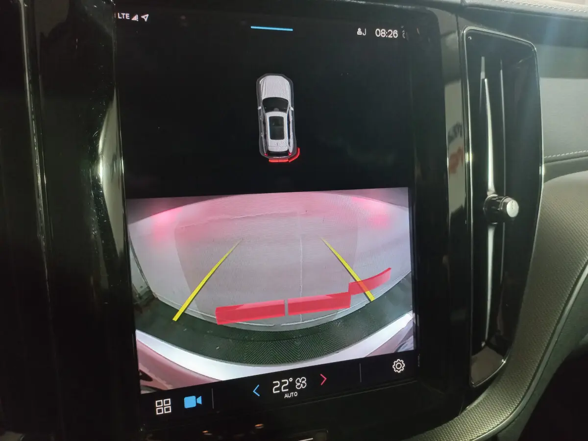 Écran tactile intérieur montrant la caméra de recul avec guidage et alertes du Volvo XC60 gris clair B4 2022.