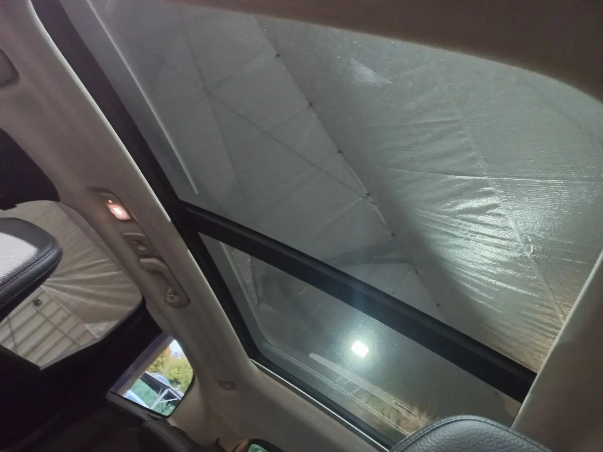 Toit panoramique en verre du Volvo XC60 B4 gris clair vu de l'intérieur côté arrière droit