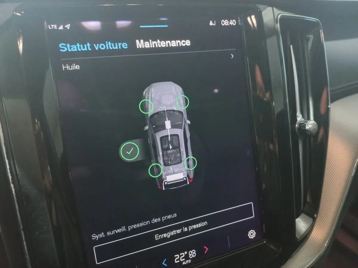 Écran tactile intérieur du Volvo XC60 B4 gris clair affichant le statut maintenance et pression pneus.