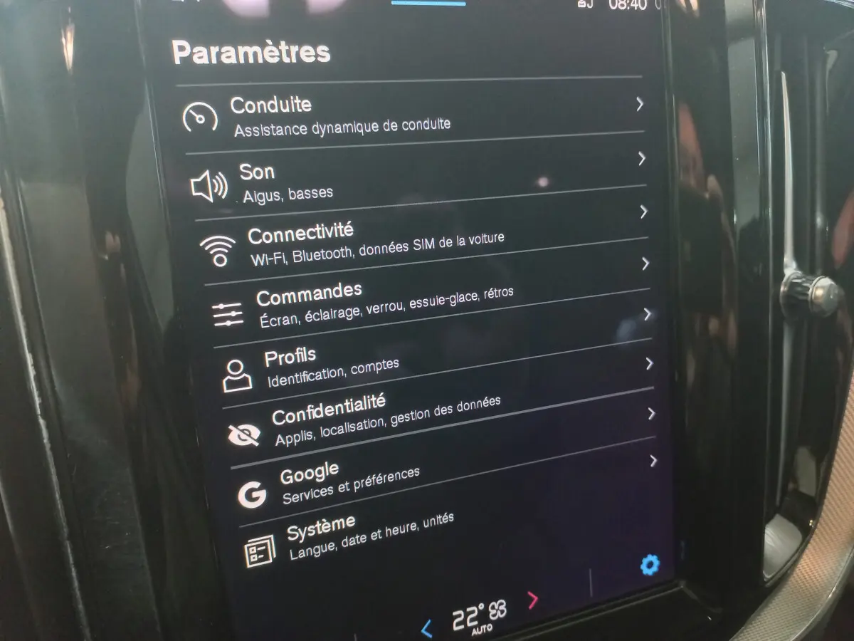 Écran tactile central affichant les paramètres du système multimédia dans un Volvo XC60 gris clair, vue intérieure rapprochée.