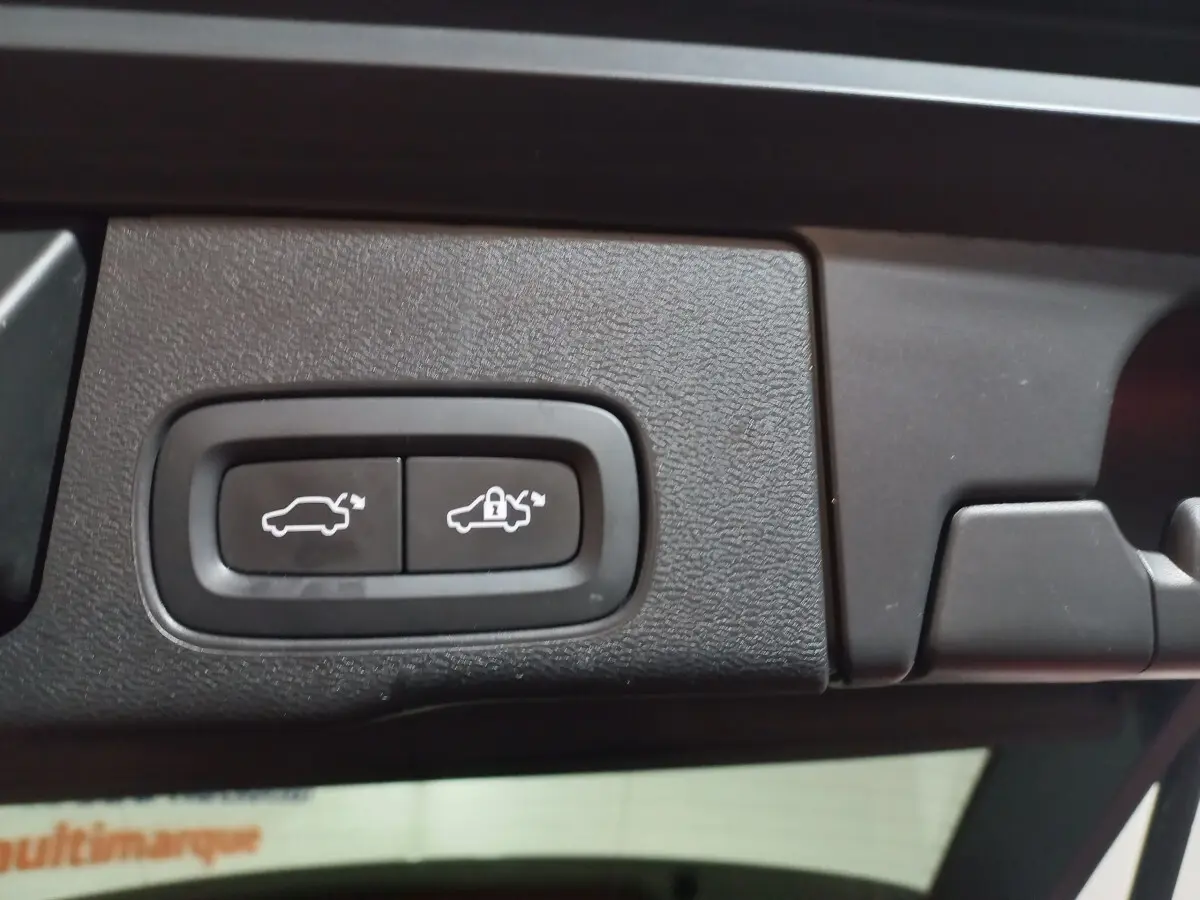 Gros plan sur les boutons d'ouverture et de verrouillage électrique du coffre du Volvo XC60 gris clair, version Inscription.