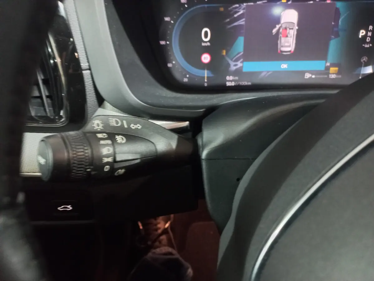 Gros plan sur la commande des phares et le tableau de bord digital du Volvo XC60 B4 gris clair, version 2022.