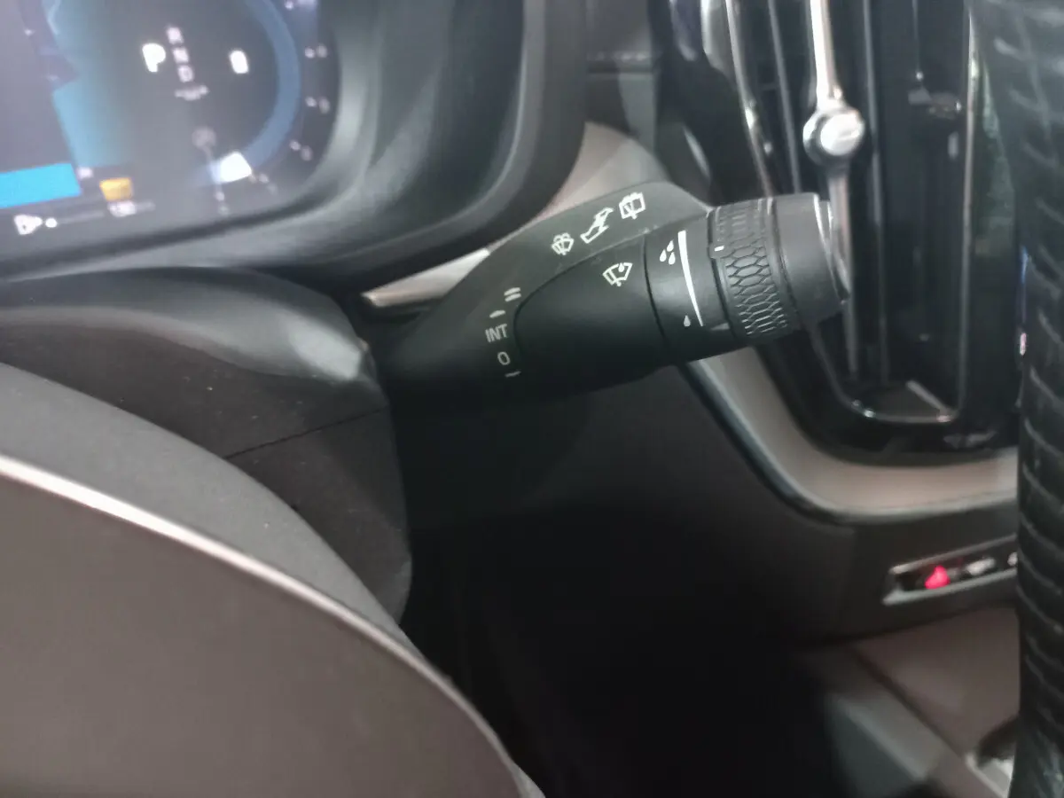 Gros plan sur la manette d’essuie-glace côté droit du tableau de bord du Volvo XC60 gris clair 2022.