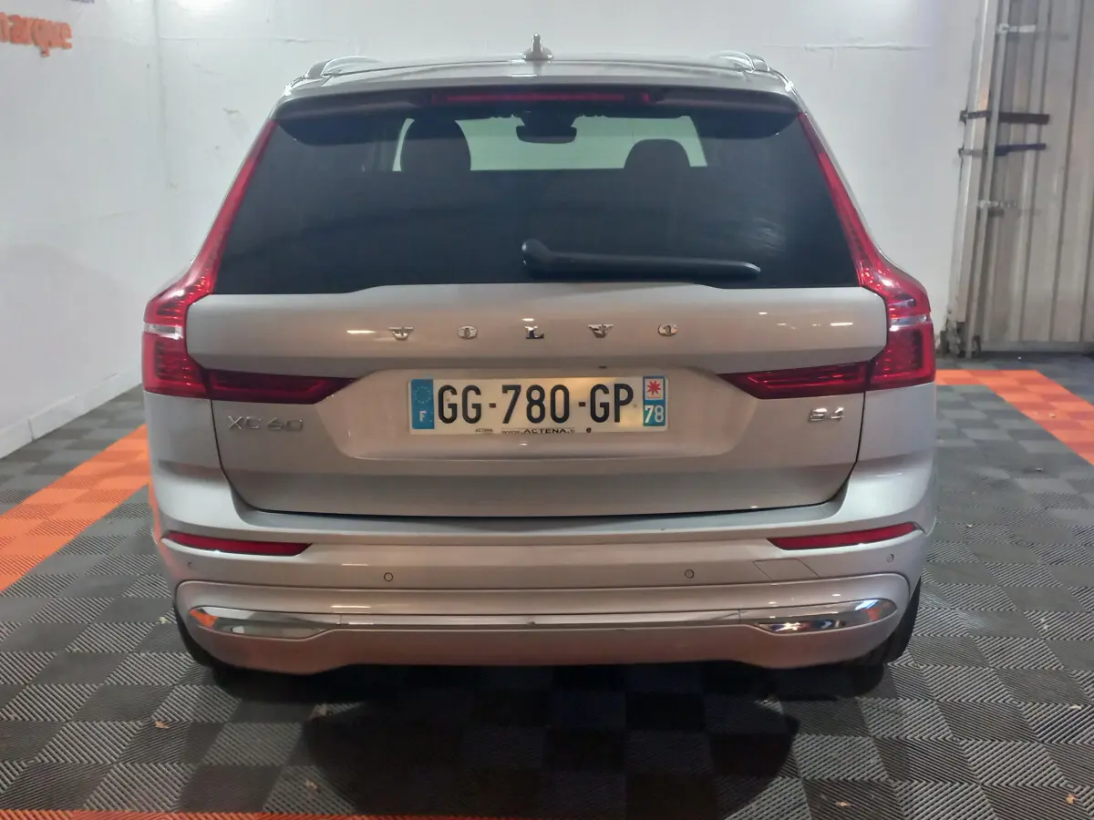 Vue arrière d'un Volvo XC60 gris clair avec feux LED caractéristiques et logo visible sur coffre.