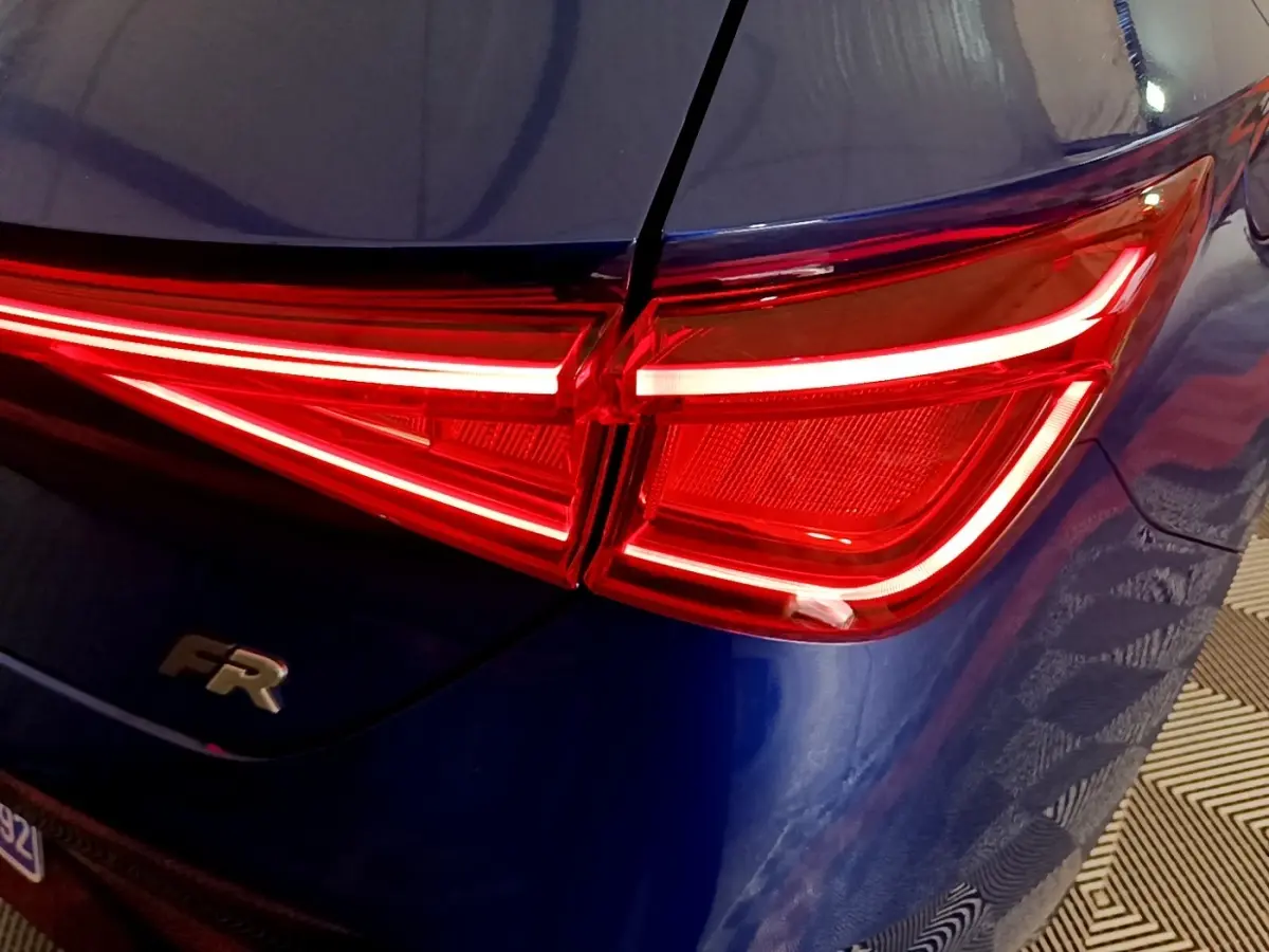 Feu arrière droit allumé sur SEAT Leon bleu 2021, version FR avec logo distinctif sur le hayon.