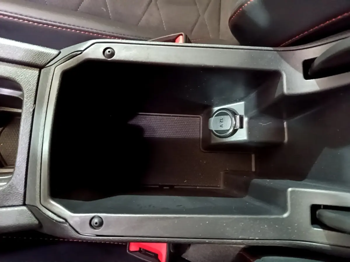 Vue rapprochée de la console centrale noire avec prise 12V du SEAT Leon 1.5 eTSI 150 DSG FR 2021.