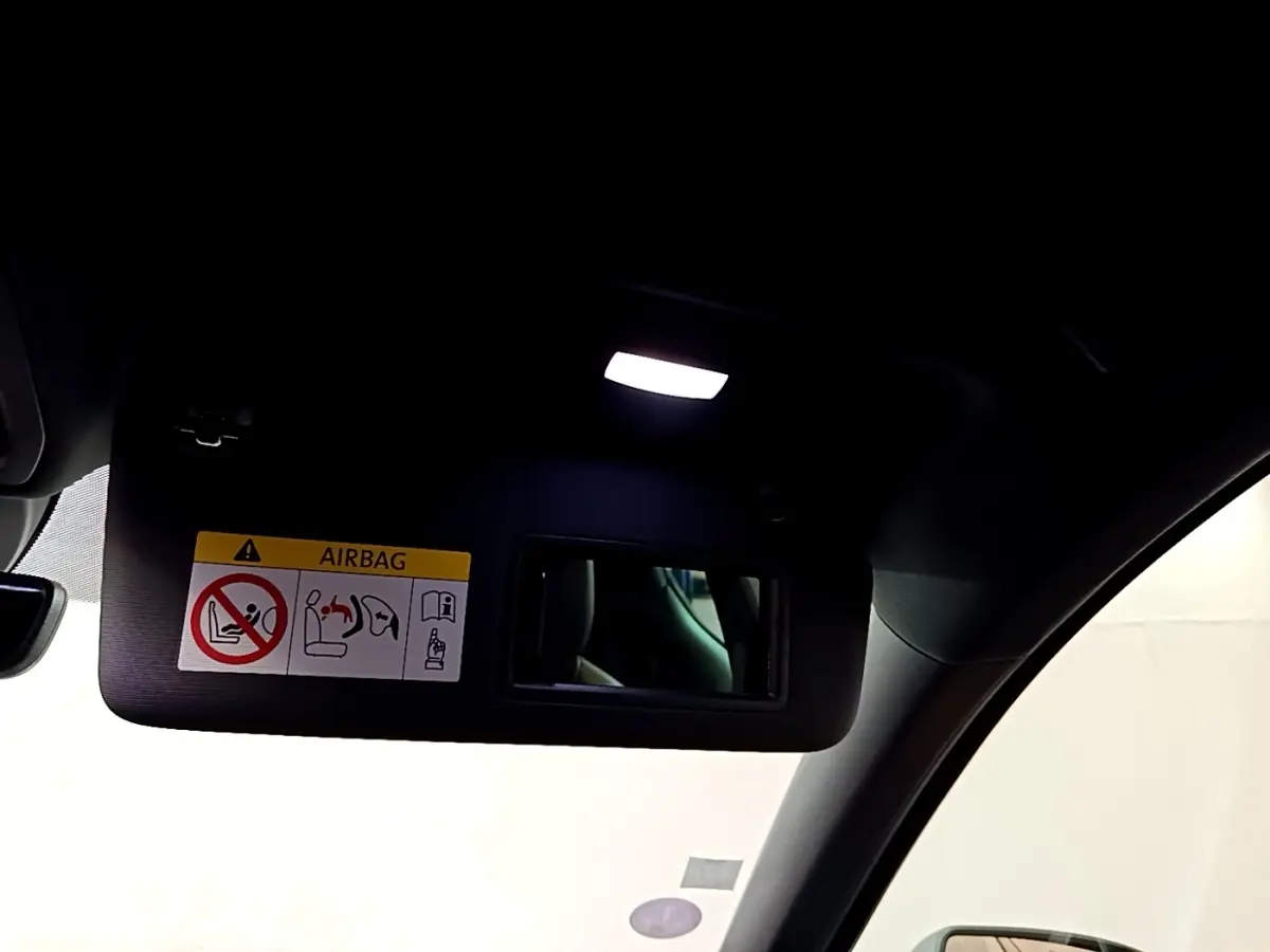 Détail intérieur du pare-soleil côté conducteur avec miroir et éclairage dans une SEAT Leon bleu 2021.