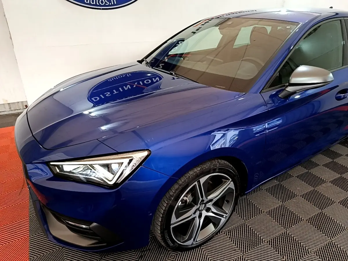 Vue 3/4 avant gauche d'une SEAT Leon bleu électrique avec phares LED et jantes alliage distinctives.