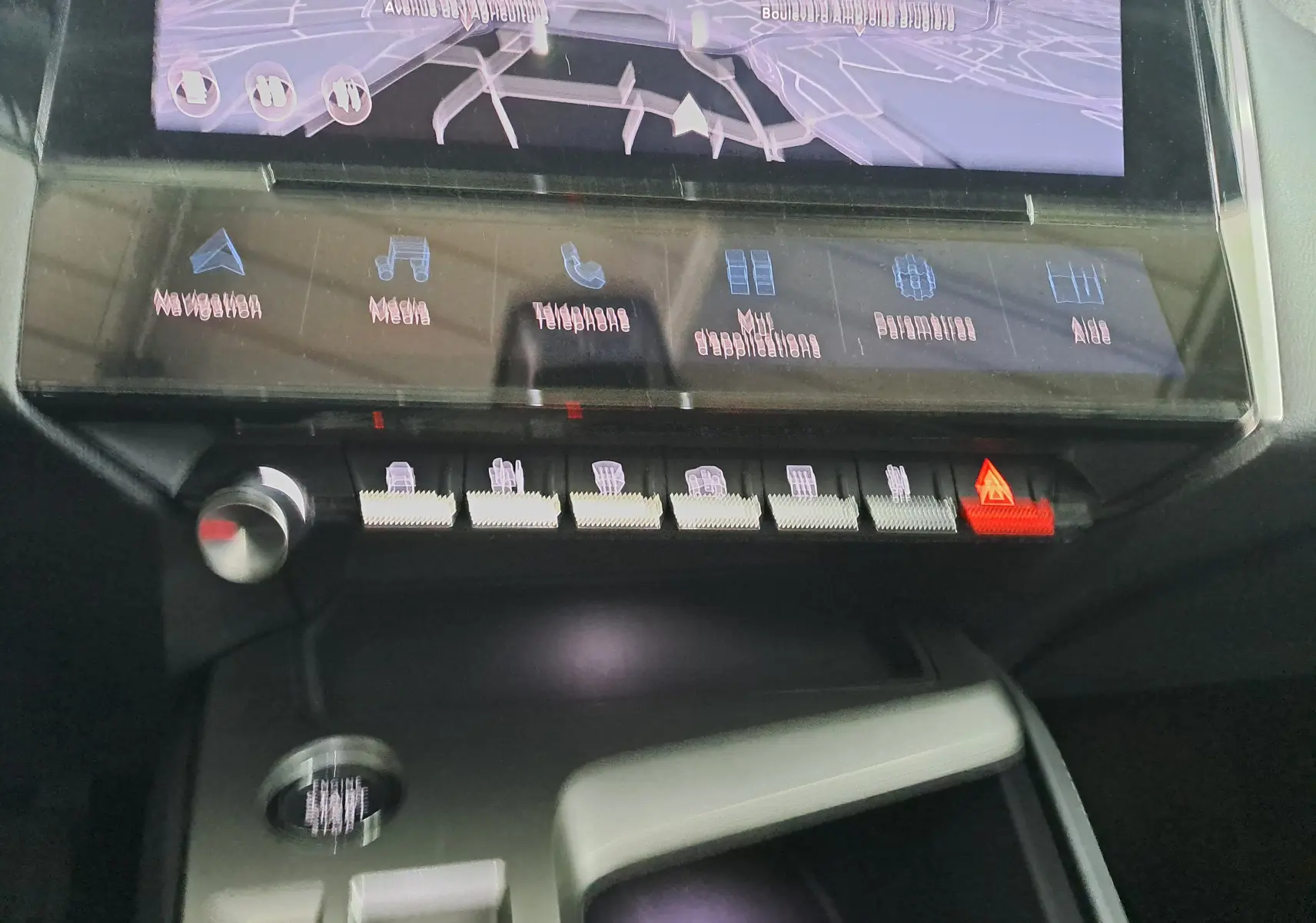 Vue rapprochée de la console centrale de la Peugeot 308 gris Artense 2023, avec écran tactile et boutons de commande éclairés.