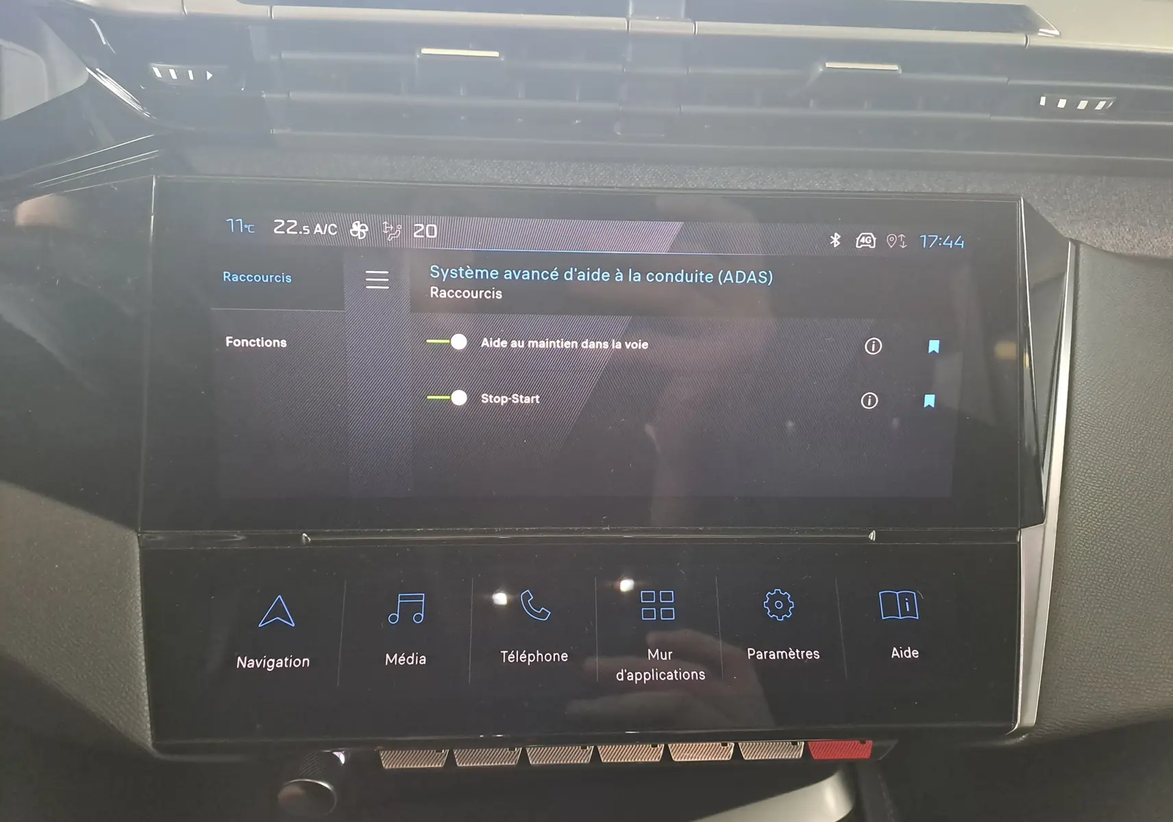 Écran tactile central du tableau de bord de la Peugeot 308 gris Artense, affichant les aides à la conduite avancées.