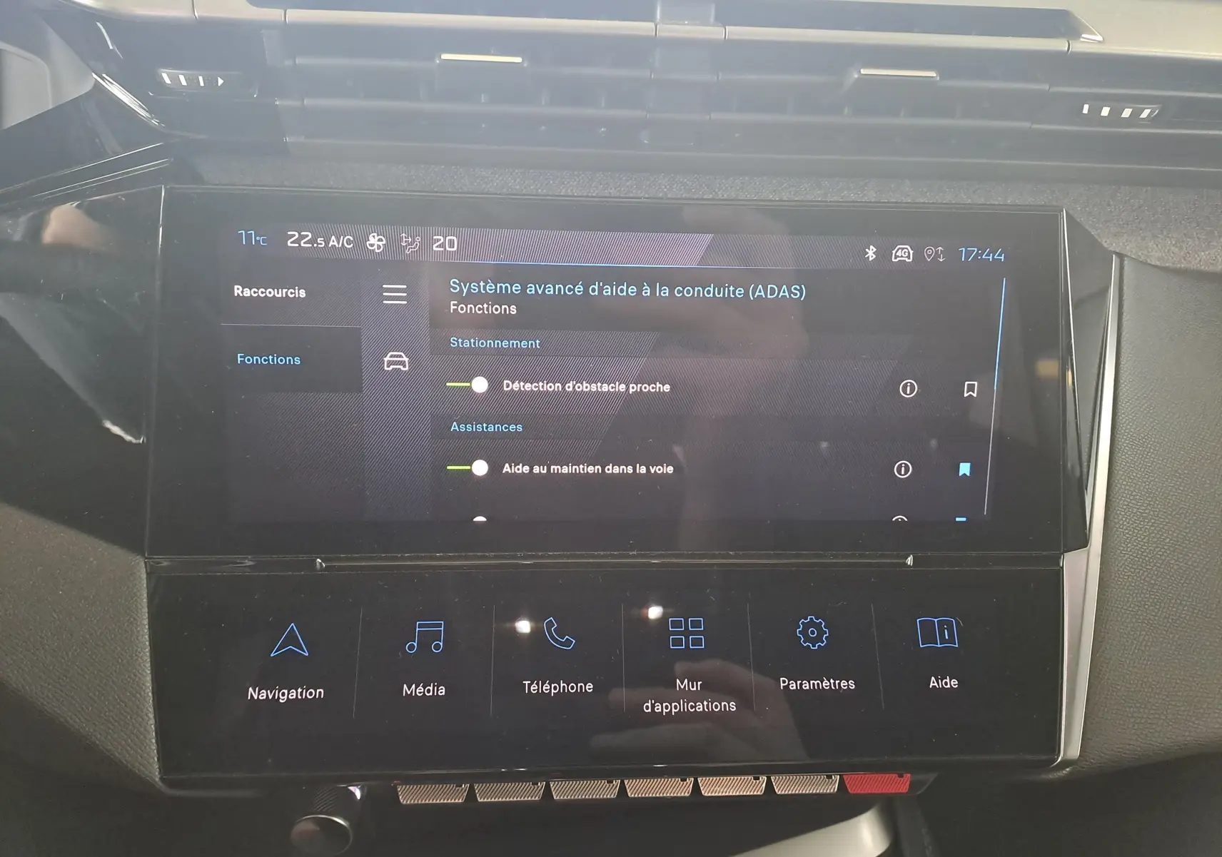 Écran tactile central du tableau de bord de la Peugeot 308 gris Artense 2023 affichant les aides à la conduite avancées.
