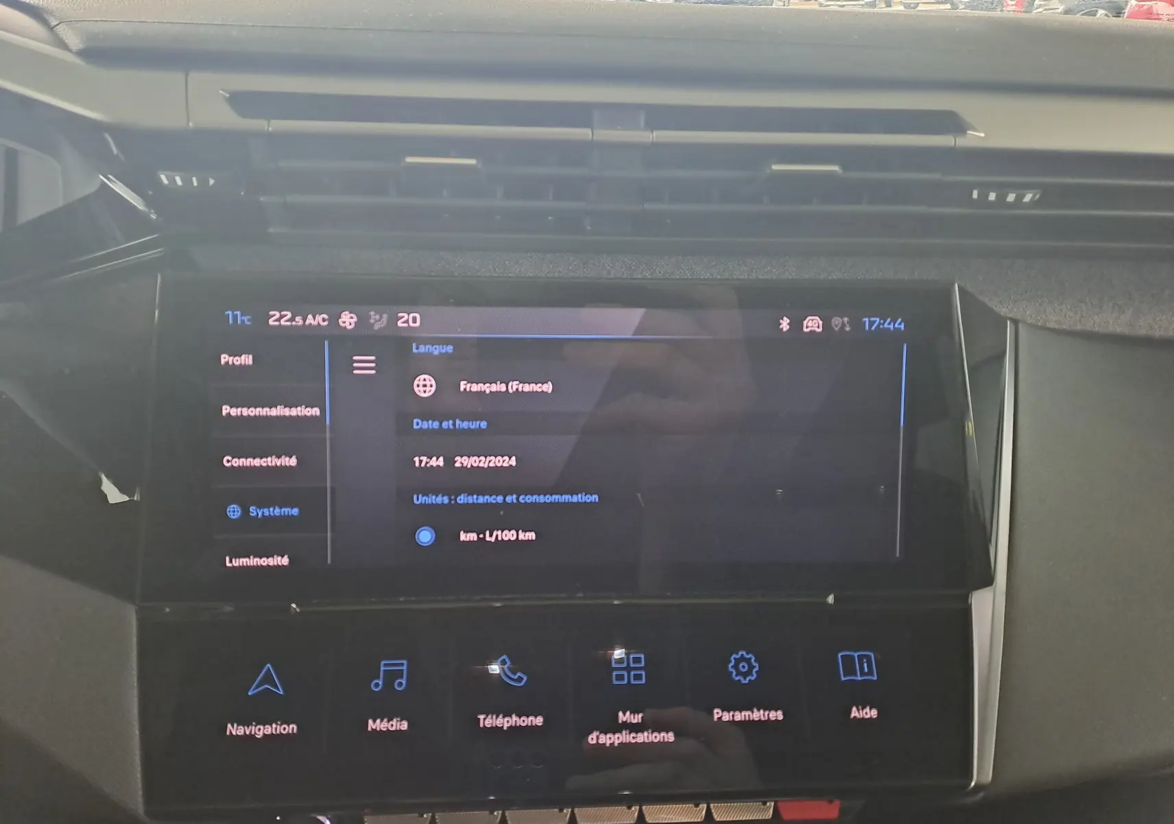 Écran tactile central de la Peugeot 308 gris Artense 2023, affichant les réglages système et options multimédia.