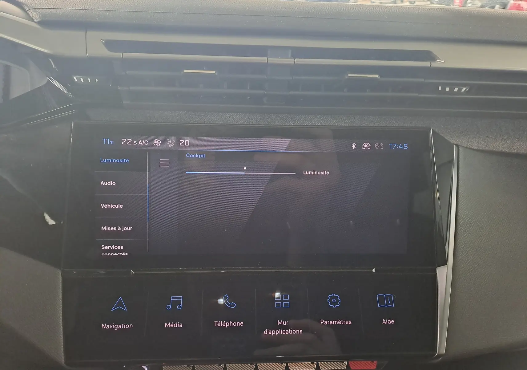 Écran tactile central de la Peugeot 308 gris Artense, vue frontale du tableau de bord avec menu luminosité affiché.