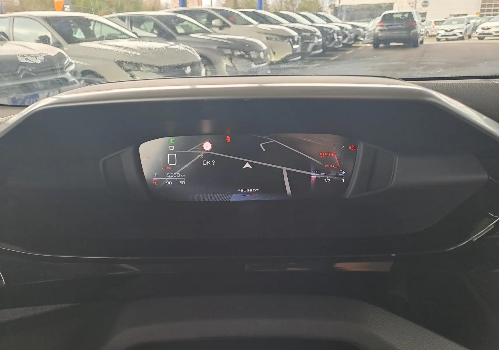 Affichage numérique du tableau de bord de la Peugeot 308 gris Artense 2023, avec navigation et mode sport visible.