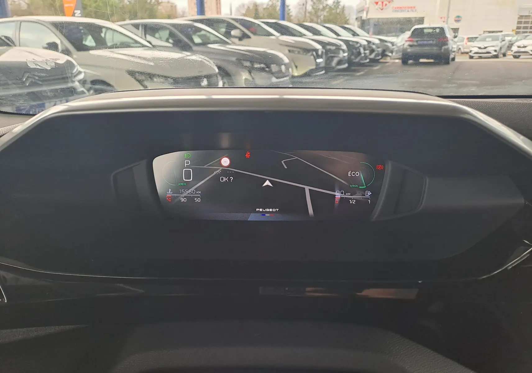 Tableau de bord numérique du Peugeot 308 gris Artense 2023 affichant la navigation et indicateurs de conduite.