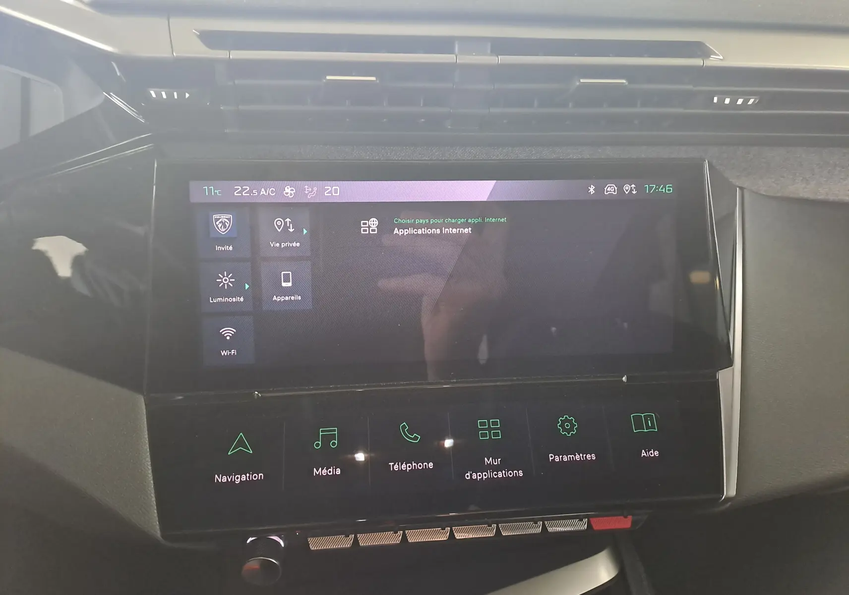 Écran tactile central allumé du tableau de bord de la Peugeot 308 gris Artense, affichant les applications internet et commandes multimédia.